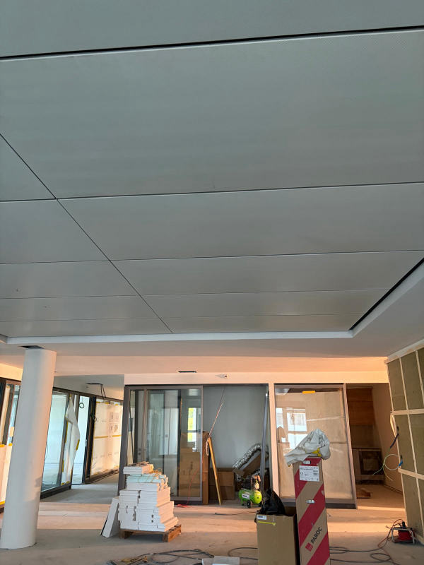 Grand faux-plafond de local commercial — Panneaux alignés au millimètre, chantier Ahmed Peintre Rénovation Sàrl