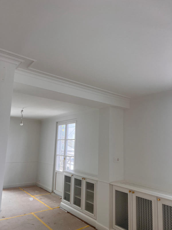 Séjour rénové avec corniches — Boiseries, moulures et murs remis à neuf, chantier Ahmed Peintre Rénovation Sàrl